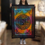 Person holding a colorful tapestry with a symbol design