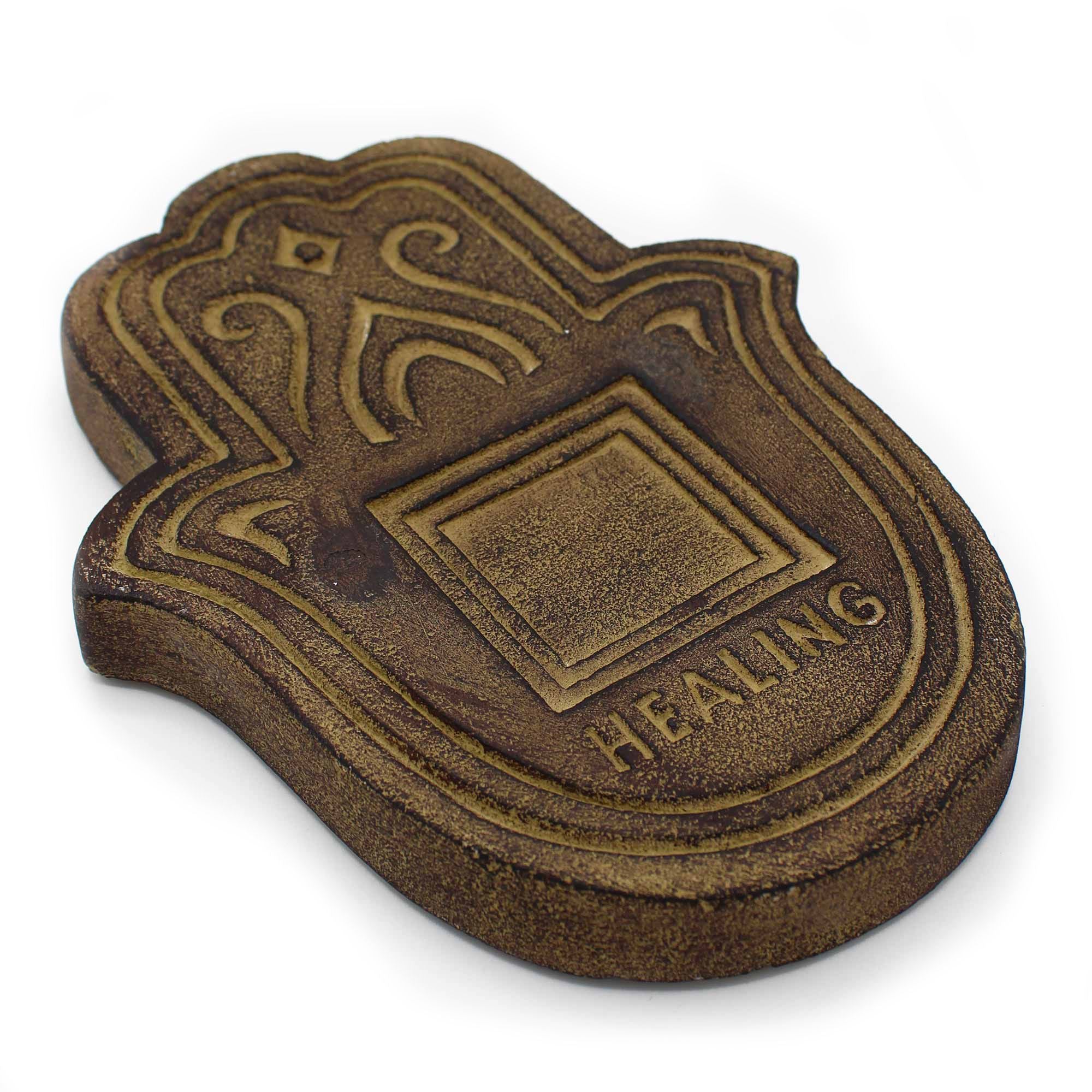 Bronze-colored decorative item with 'HEALING' text on a white background