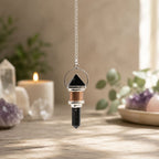 Crystal pendulum on a wooden surface with blurred background