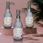 Three Agnes & Cat hand and body cream bottles with floral labels on a pink background.