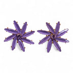 Pair of purple star-shaped earrings on a white background