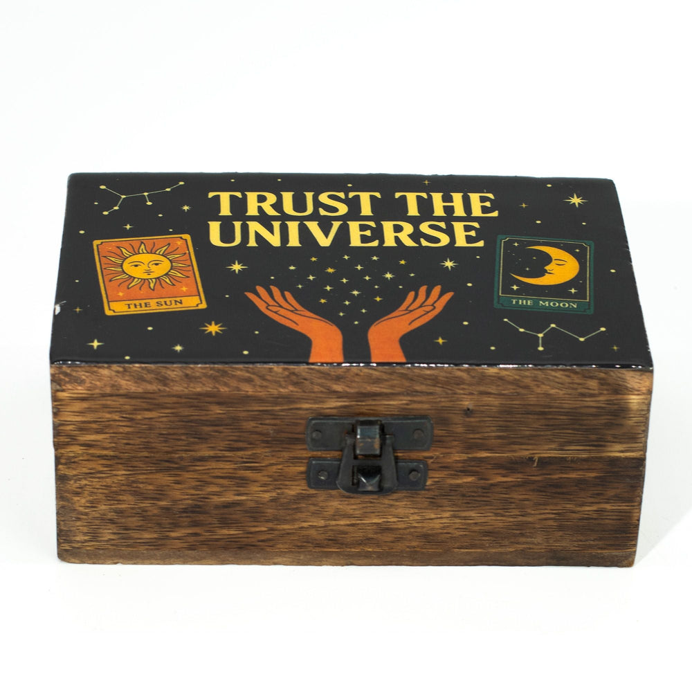 Wooden box with 'Trust the Universe' text and celestial designs on a black background