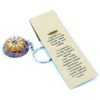 Keychain with decorative ball and educational card on a white background