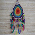 Colorful dreamcatcher with feathers on a woven background