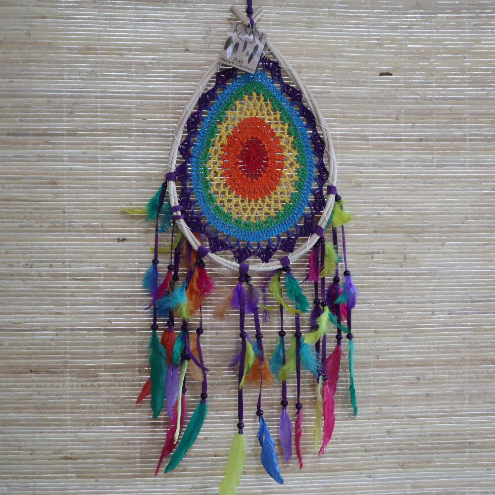Colorful dreamcatcher with feathers on a woven background