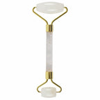 Facial roller with gold accents and white marble handle on a white background