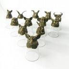 Bronze animal head figurines on clear stands against a white background