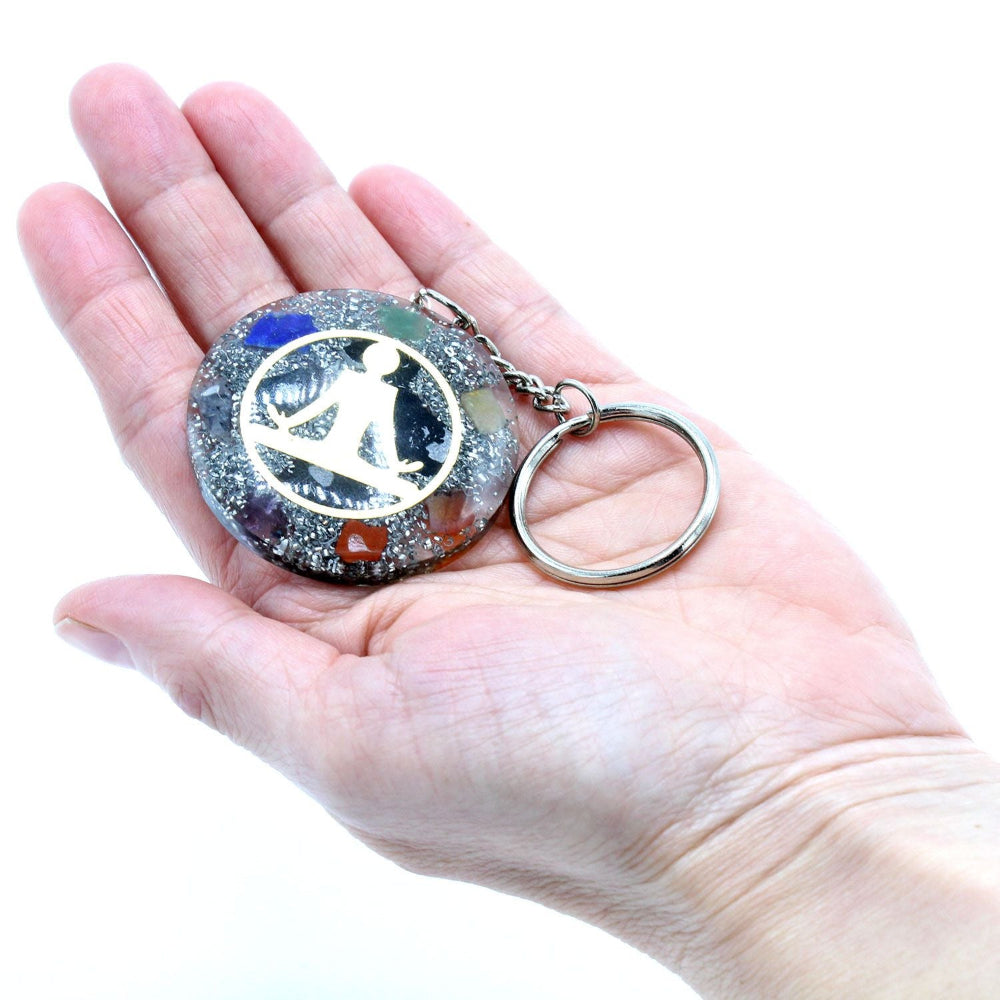 Keychain with a decorative design held in a hand against a white background