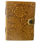 Brown leather journal with floral embossing on a white background
