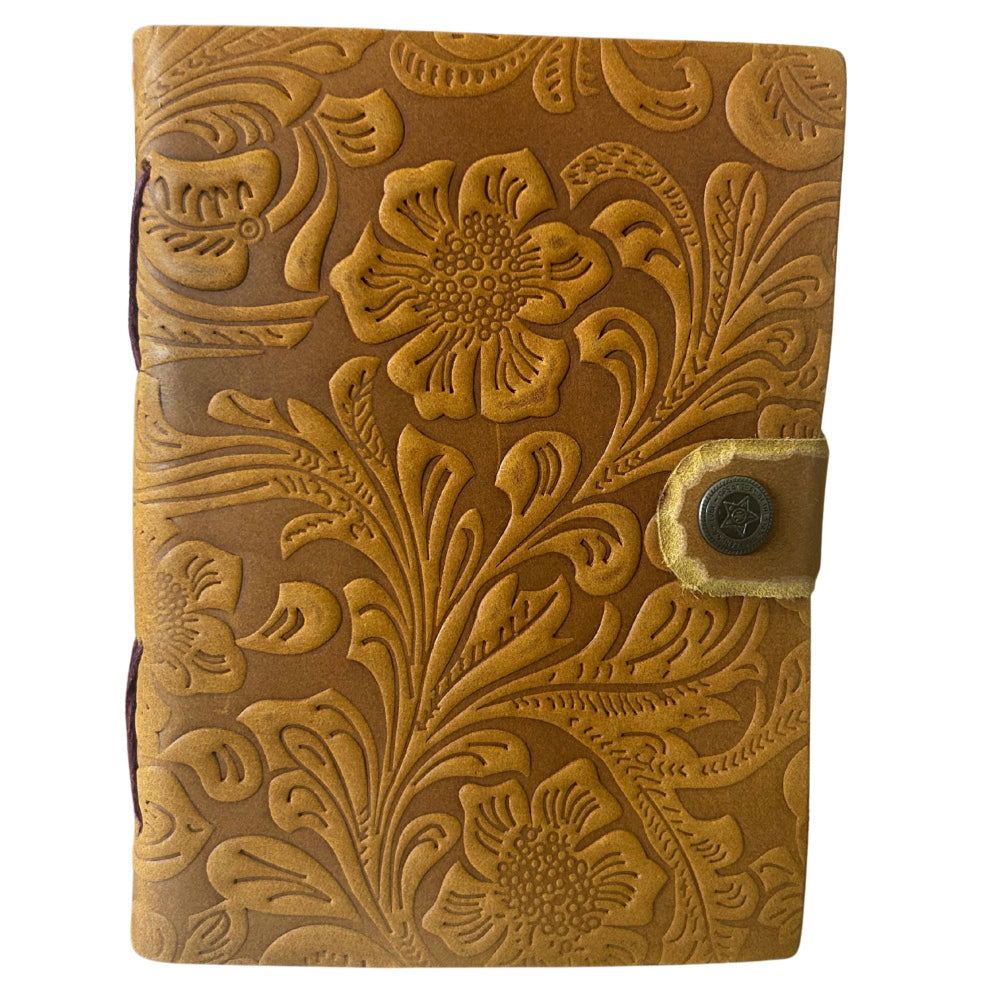 Brown leather journal with floral embossing on a white background