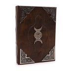 Decorative leather book with embossed design and silver emblem on a white background