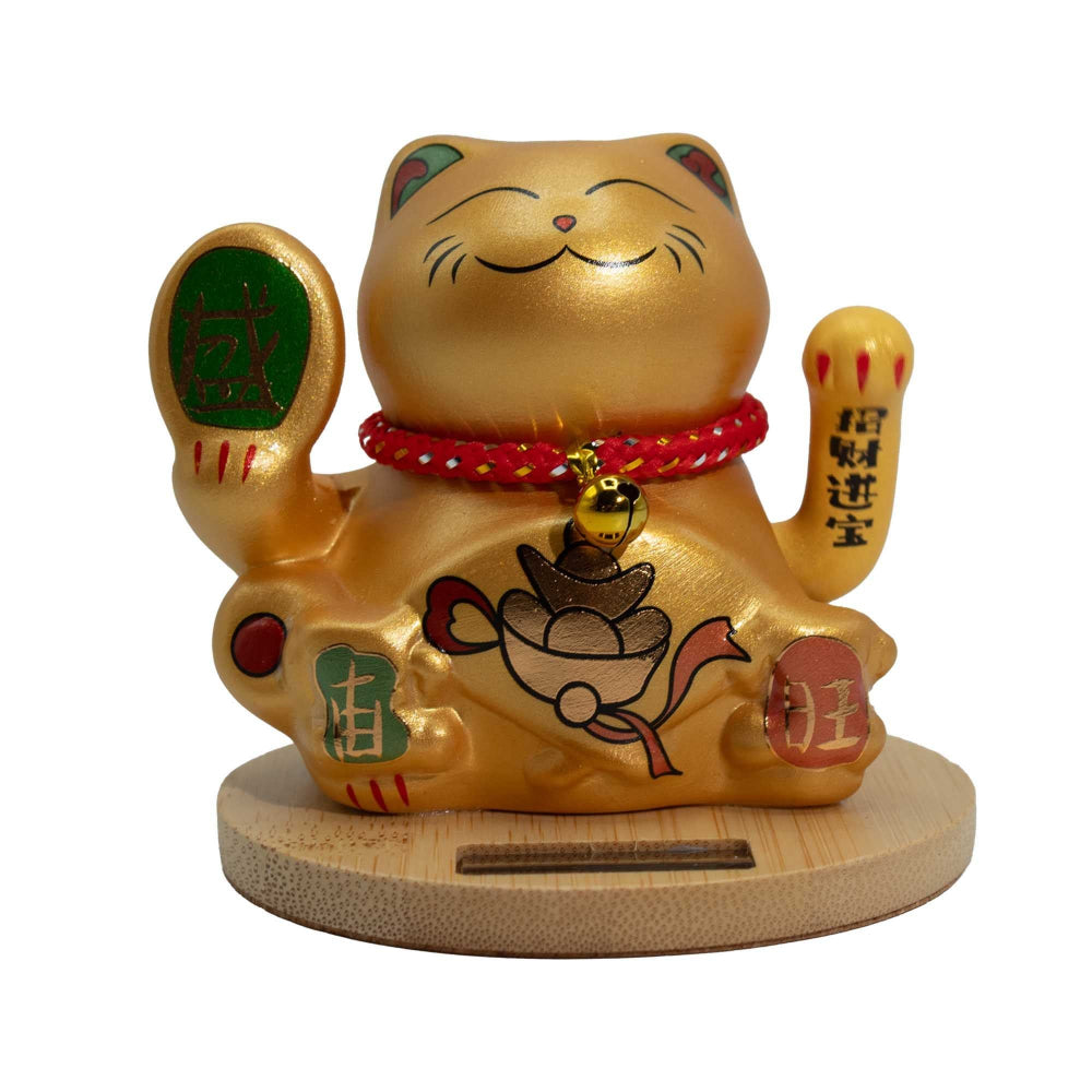 Gold cat figurine with raised paw on a white background