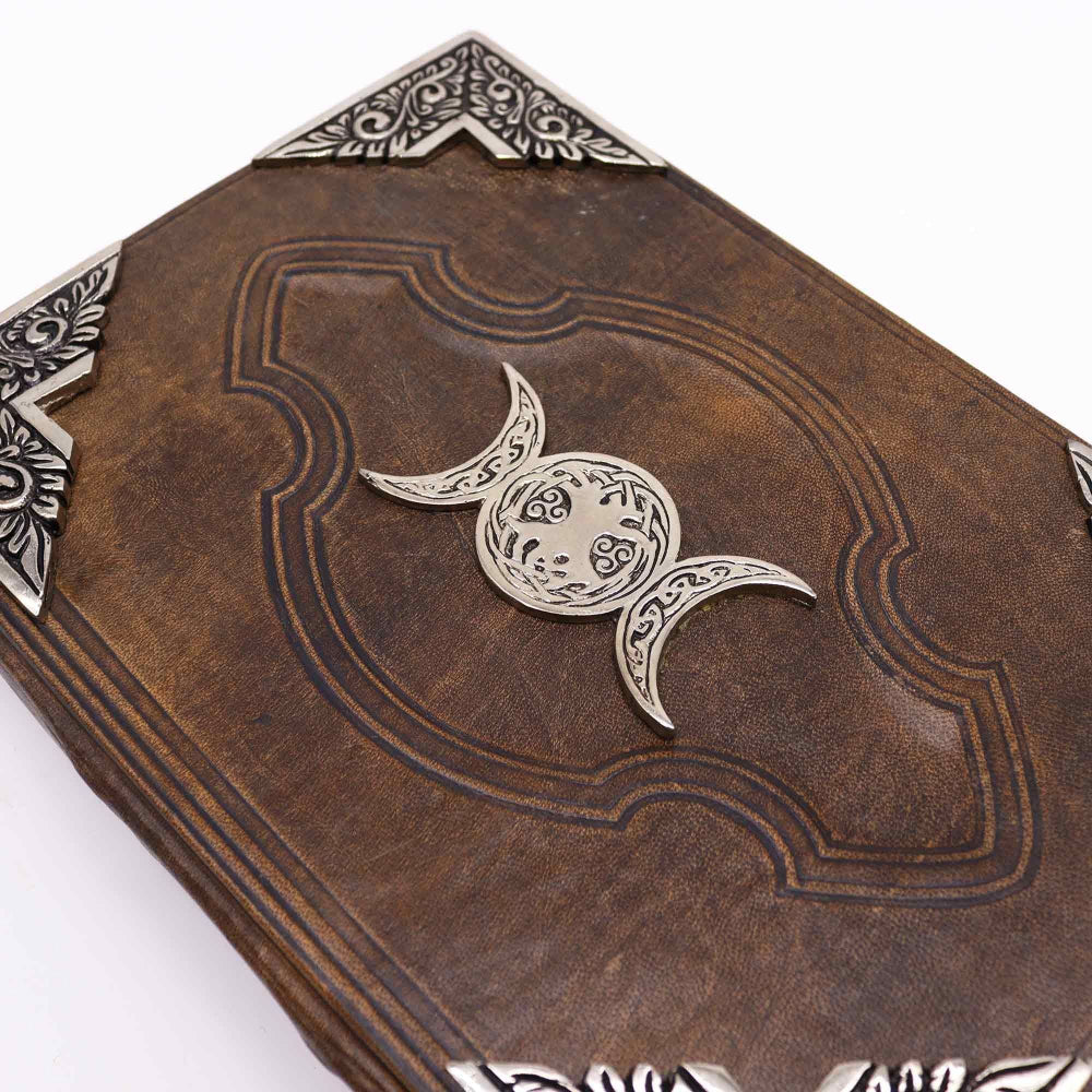 Decorative leather book with silver crescent moon design on a white background