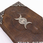 Decorative leather book with silver crescent moon design on a white background