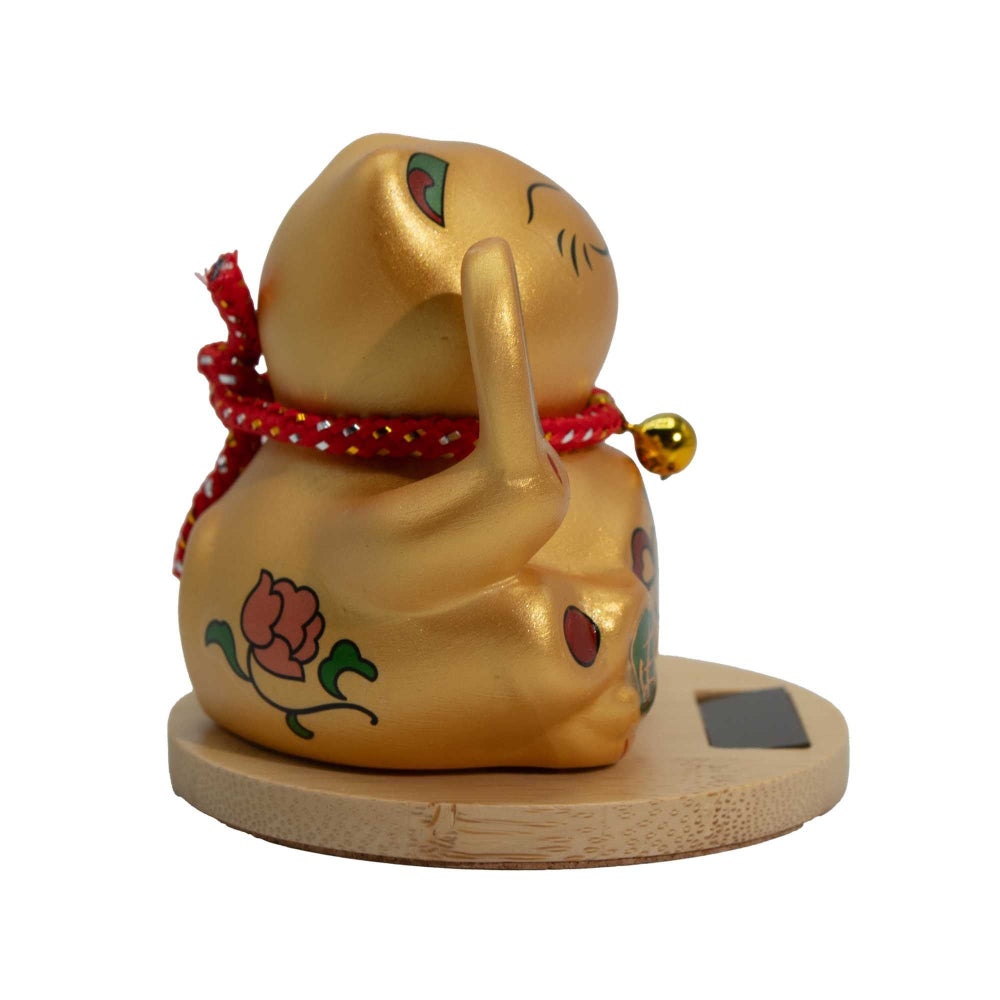 Gold cat figurine with a red scarf and bell on a white background