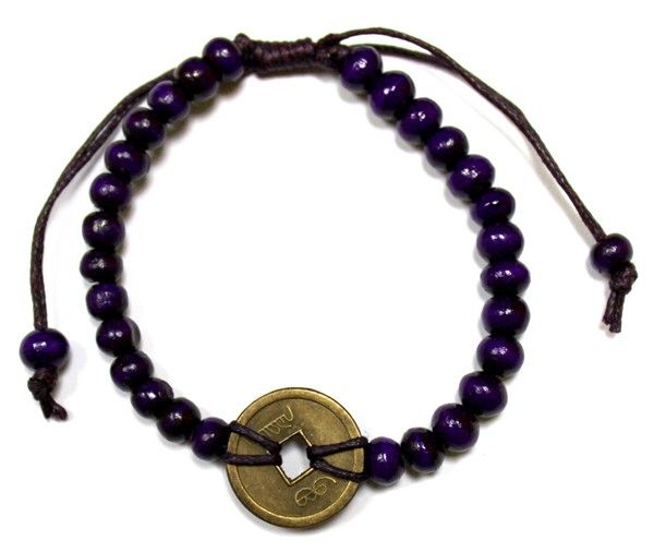 Purple beaded bracelet with a gold coin charm on a white background