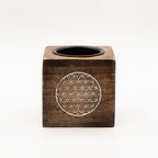 Wooden cube with circular design and black center on a white background