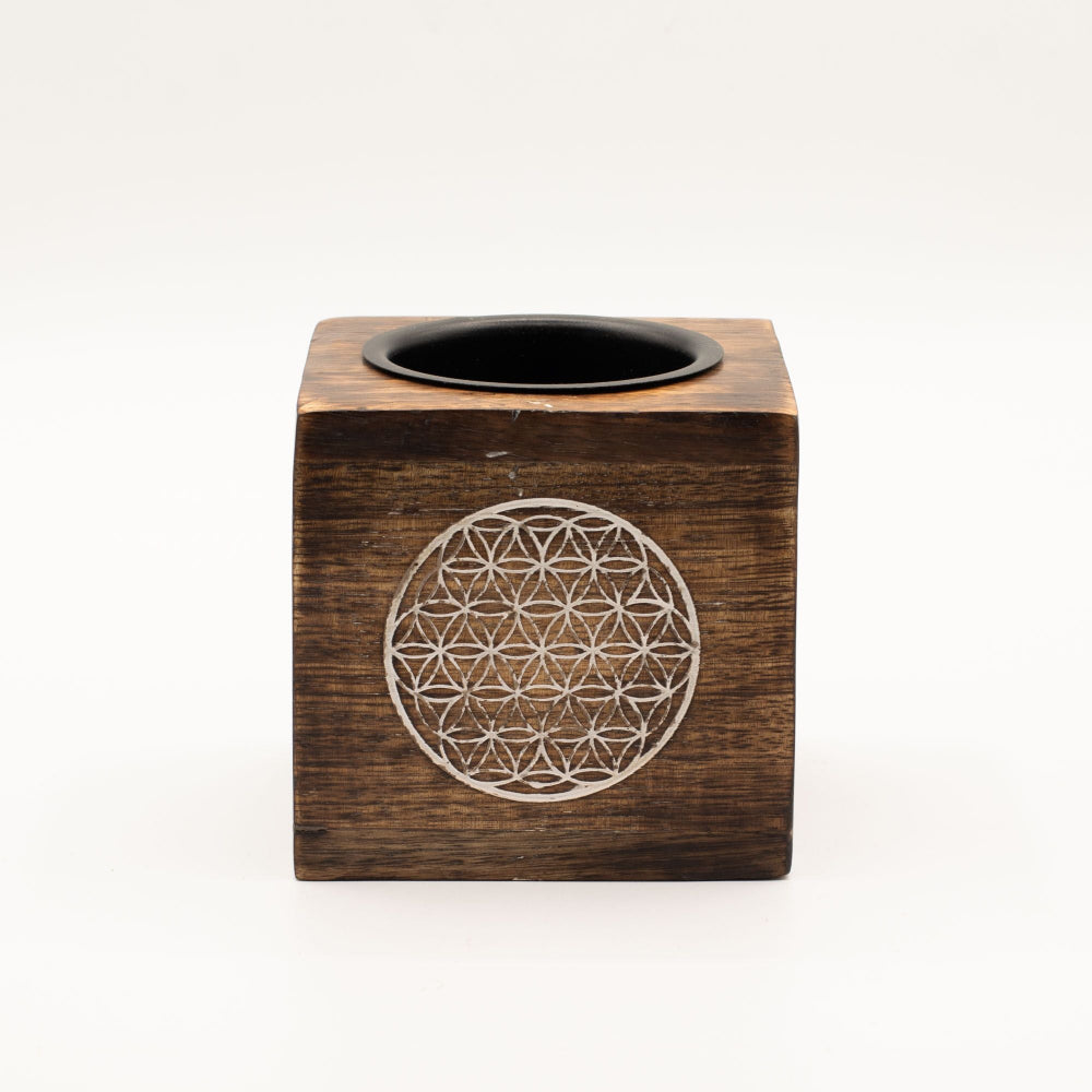Wooden cube with circular design and black center on a white background