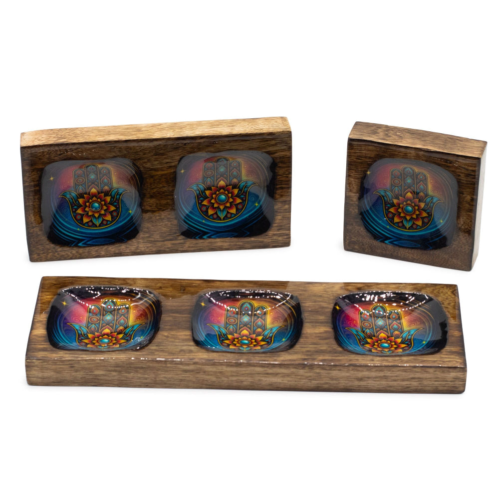 Set of four colorful glass bowls in wooden stands on a white background