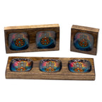 Set of four colorful glass bowls in wooden stands on a white background