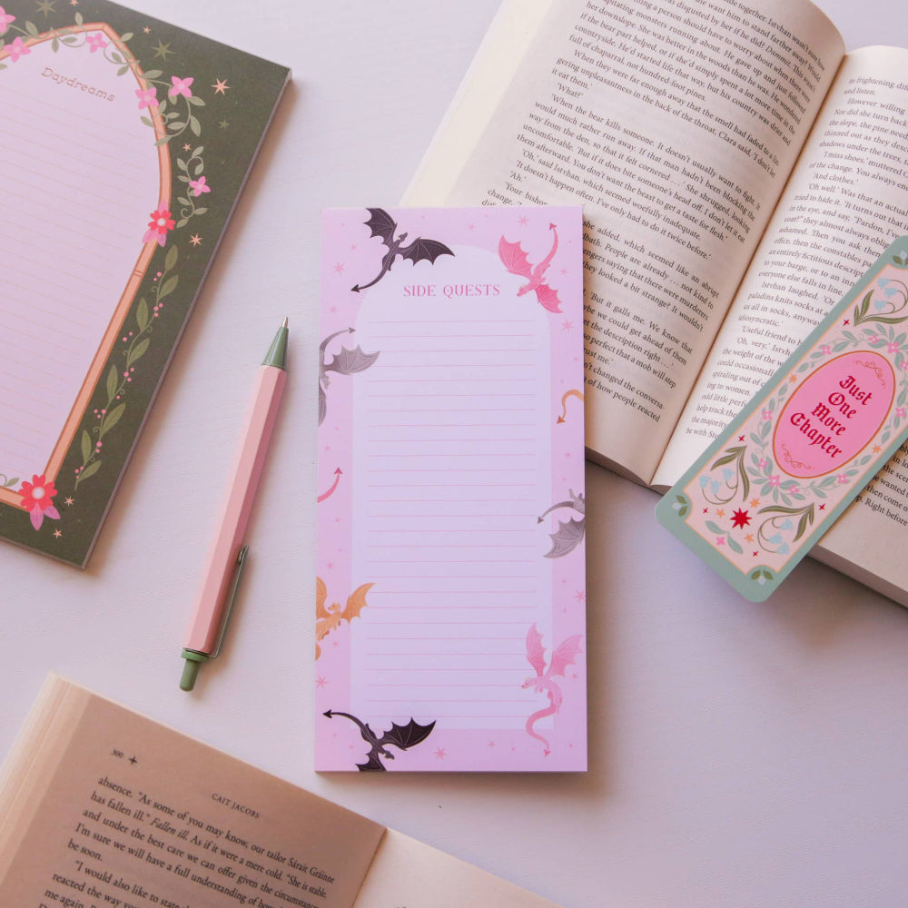 Notepad with fairy design, pen, and bookmark on an open book