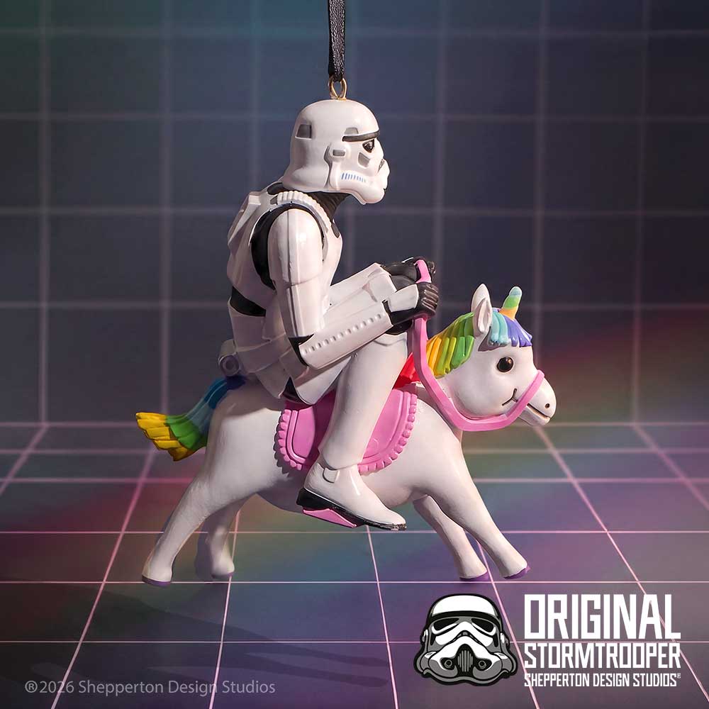 A Star Wars-themed hanging ornament featuring a white Stormtrooper riding a white pony with a rainbow mane and tail, suspended against a dark grid background. Text at the bottom right reads 'Original Stormtrooper' with Shepperton Design Studios branding.