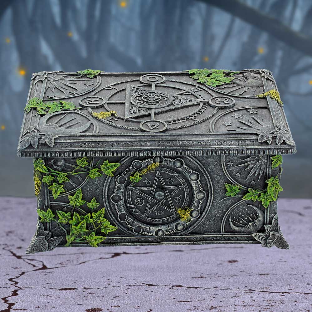 decorative box with mystical symbols and greenery on a textured surface suitable for holding tarot cards. 